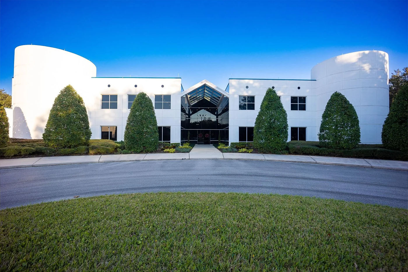 Deerwood Castle event venue exterior in Southside Jacksonville FL, modern white building with curved towers, glass entrance, circular driveway and manicured grounds