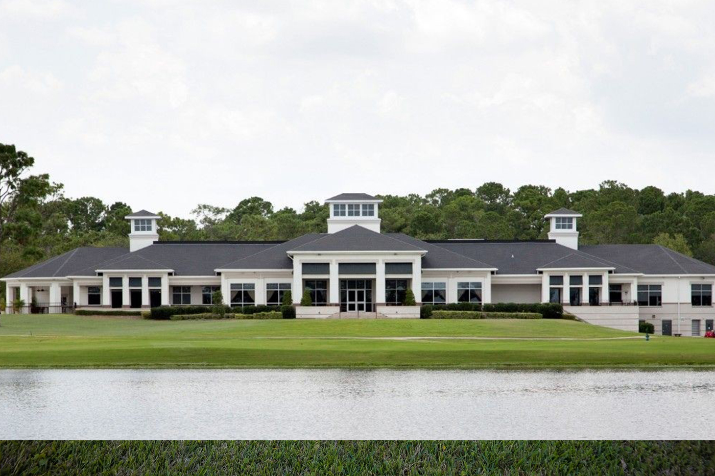 Deerwood Country Club wedding venue in Southside Jacksonville FL, large white clubhouse with columns and cupolas overlooking a golf course pond