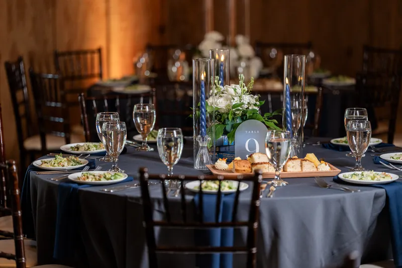 Reception table detail with navy linens and floral centerpiece at Bowing Oaks, Jacksonville FL