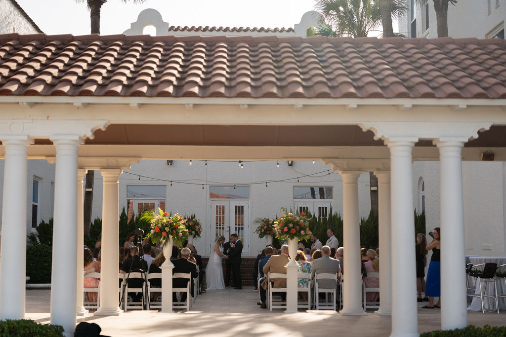 Wedding ceremony viewed through the arched colonnade at Casa Marina Hotel, Jacksonville Beach FL