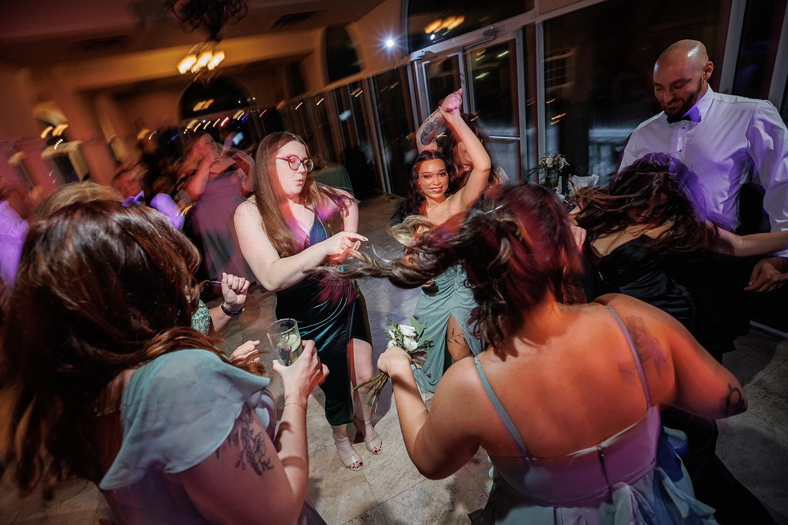 Wedding guests and bridesmaids dancing with uplighting at Club Continental Orange Park FL — Footloose Entertainment wedding DJ