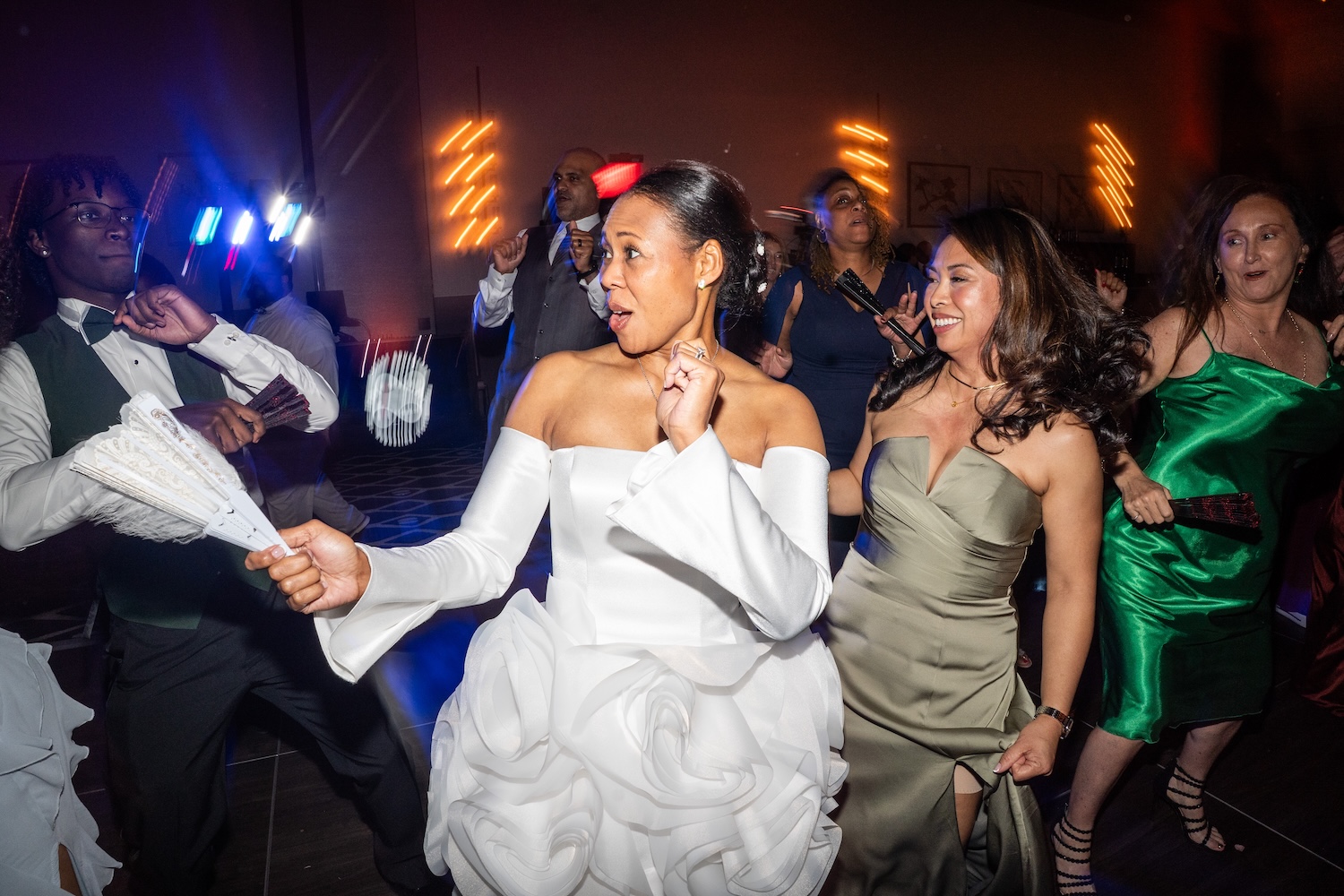 Wedding reception guests dancing at Embassy Suites St. Augustine FL, colorful DJ uplighting, bride celebrating on the dance floor with guests