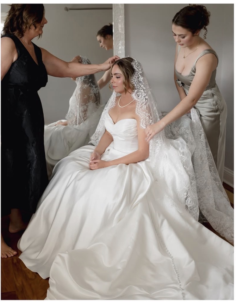 Bride seated at a vanity mirror getting ready in the bridal suite at The Manor at 12 Oaks Green Cove Springs FL