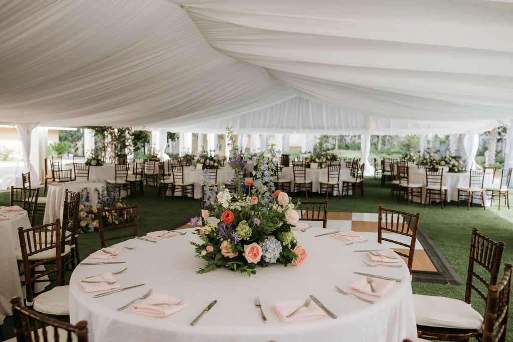 Tented reception setup at Omni Amelia Island with floral centerpieces and chiavari chairs, Fernandina Beach FL