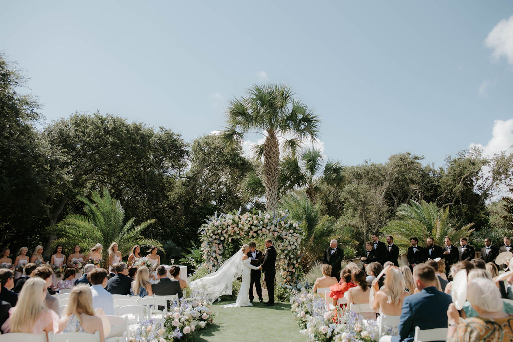 Outdoor wedding ceremony on the event lawn at Omni Amelia Island with floral arch and palm trees, Amelia Island FL