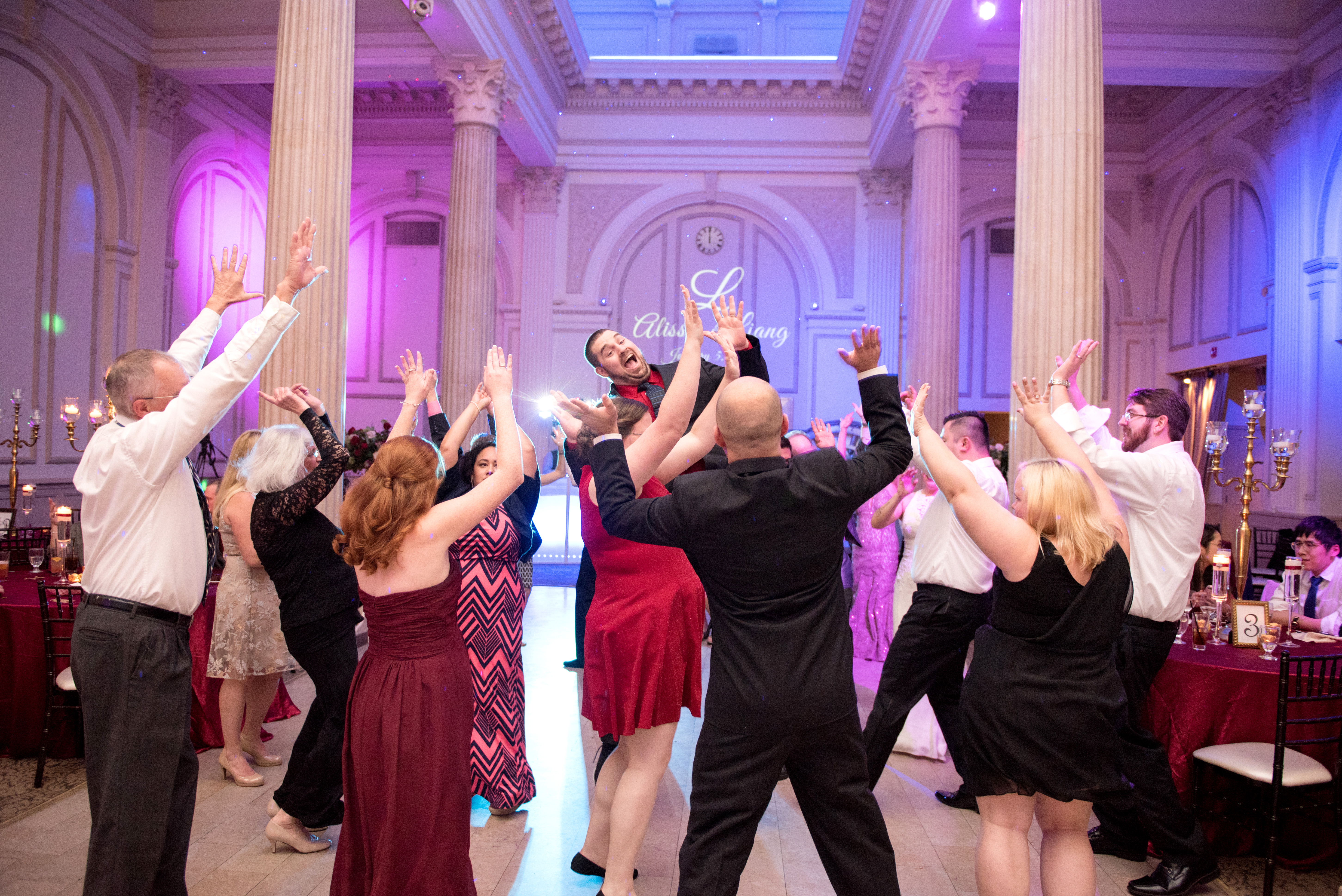 Wedding reception with purple uplighting and monogram projection at Treasury on the Plaza St Augustine FL — Footloose Entertainment wedding DJ