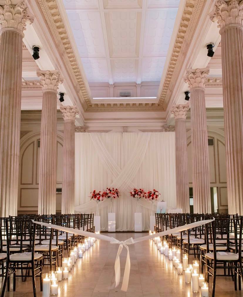 Wedding ceremony setup with candle-lined aisle and Corinthian columns at Treasury on the Plaza St Augustine FL — Footloose Entertainment