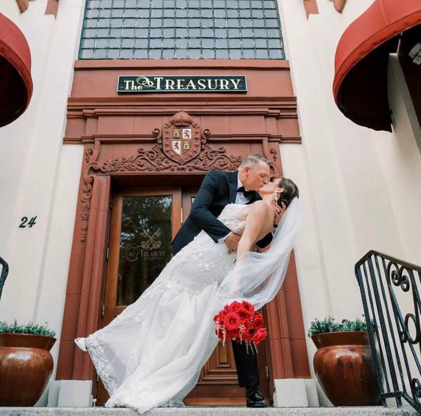 Bride and groom dip kiss at The Treasury on the Plaza entrance in St Augustine FL — Footloose Entertainment wedding DJ